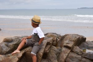 Petit garçon sur les rochers sur la plage