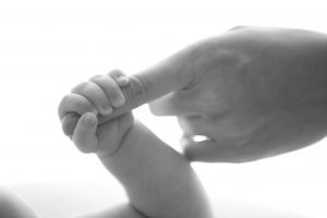 Doigt d'une maman dans la main de son bébé