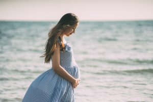 Maternité : femme enceinte sur la plage en été