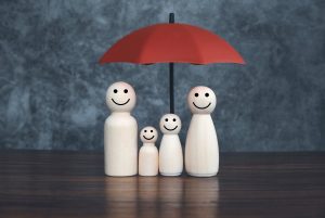 Famille protégée par la souscription d'une assurance décès, représentée par un parapluie
